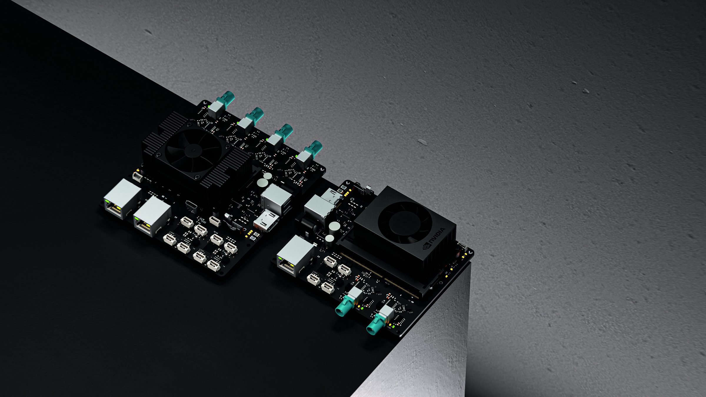 Two compute boards with camera connectors and cooled processors, on the edge of a dark plinth
